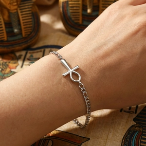 Silver Ankh bracelet on wrist with ancient Egyptian pharaoh and papyrus background