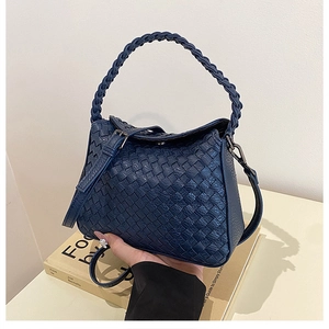 Macro view of blue hand-woven hobo bag with thick handle and silver hardware detail