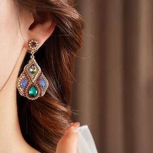 Gros plan sur des boucles d'oreilles vintage en bronze avec cristaux de zircon multicolores