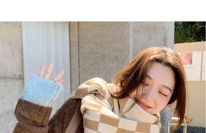 Detail of warm khaki checkered scarf paired with light blue knitted fingerless gloves