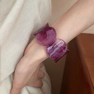 Detail of purple acrylic resin geometric bracelet with marble pattern on a woman's wrist