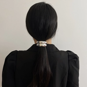 Silver arch geometric hair tie accessory shown on a sleek ponytail from a back view