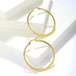 Detailed macro view of large gold-plated stainless steel hoop earrings on a white background