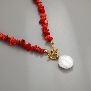 Macro detail of red gravel stone necklace with golden OT clasp and Baroque pearl pendant
