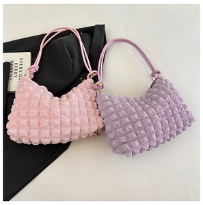 Detail of pink and purple quilted cloud bags with textured bubble fabric and woven straps