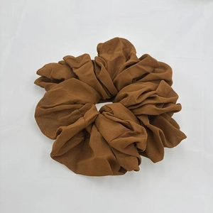 Detailed view of dark brown oversized chiffon scrunchie with soft pleated texture