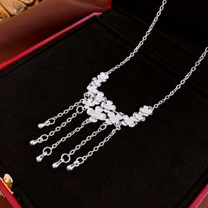 Detailed view of silver flower tassel necklace with water drop charms in a jewelry box