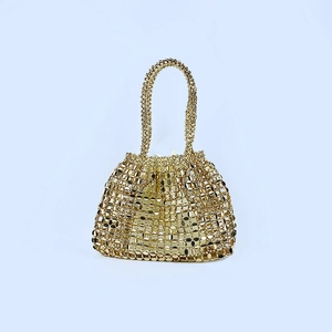 Detail view of a handmade woven golden metal mesh handbag with double handles and sequin finish