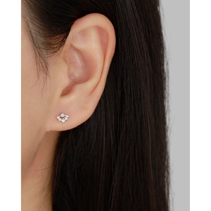 Close-up of sparkling s925 silver flower stud earring with zircon on an ear