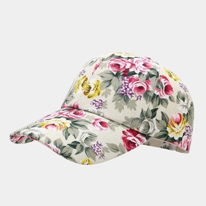 Close-up of vintage floral print details on a beige canvas baseball cap with red roses