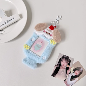 Detail of light blue plush puppy card holder with heart-shaped window and cherry charm