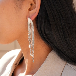 Gros plan de longues boucles d'oreilles à franges argentées avec sequins en métal