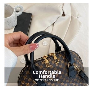 Detail showing vintage brown patterned shell bag with black handles and golden zipper