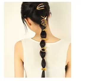 Close-up of golden geometric hair clips and pearl hairpin set on a black ponytail