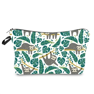 Detail of cartoon sloth and tropical leaf print on white makeup bag with black zipper