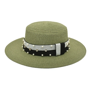 Close-up of pearl and rhinestone embellishments on green straw sun hat brim