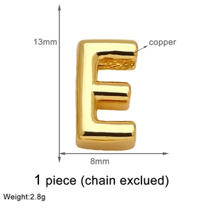 Macro view of gold-plated copper letter E pendant with dimensions 13mm by 8mm