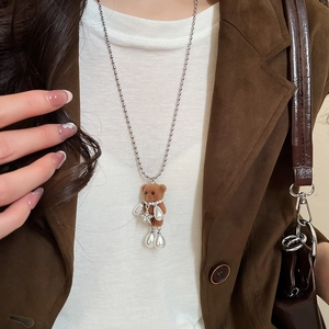 Brown flocked bear pendant on silver bead chain styled with a brown suede jacket