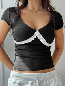 Détail du haut noir en maille Y2K avec dentelle blanche et col en V contrasté