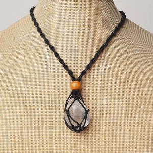 Handmade macrame net necklace with natural clear crystal stone on a mannequin display