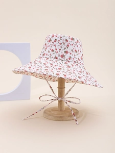 Detailed close-up of a floral sun hat with wide brim and matching tie ribbon on a stand