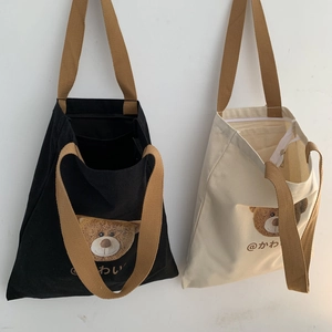 Detail view of canvas tote bags with cartoon bear print and secure zipper closure