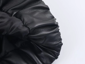 Detailed close-up of premium black leather material showing soft texture and natural folds