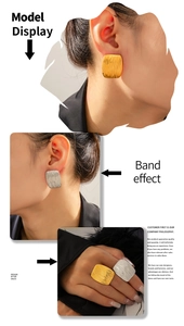 Macro detail of gold and silver square textured earrings and rings set on model