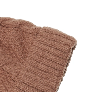 Macro view of dark brown cable-knit winter beanie showing detailed ribbed texture
