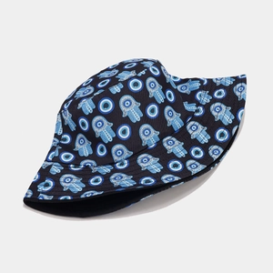 Detail of evil eye and hamsa hand patterns on black reversible bucket hat fabric
