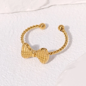 Detailed close-up of a gold-plated bow ring featuring a unique twisted rope band texture