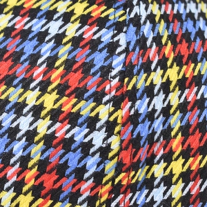 Macro shot of multi-color houndstooth fabric texture with detailed stitching for baseball cap