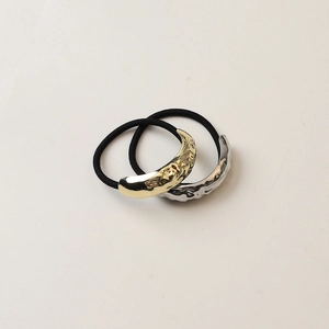 Detail of high-elastic hair ties with hammered textured gold and silver crescent charms