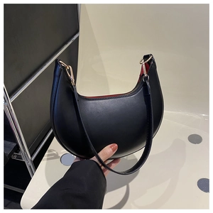 Detail view of black crescent shoulder bag with smooth matte finish and gold hardware