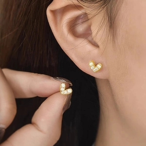 Exquisite gold heart stud earrings with micro-set zircons on female ear for daily wear