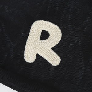 Black knit beanie featuring a vintage white R-letter patch with textured embroidery