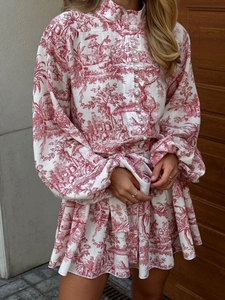Détail du motif Toile de Jouy rouge sur robe blanche avec manches lanternes et boutons nacrés
