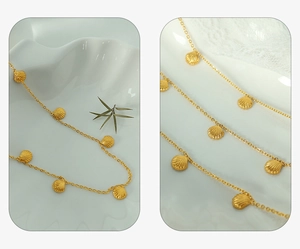 Detail of elegant gold necklace featuring multiple small seashell pendants on fine link chain