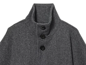 Gros plan d'une veste en laine gris foncé avec col montant et boutons noirs