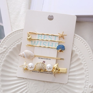 Starfish and seashell hair clip set with pearls and gold starfish hairpins on a card