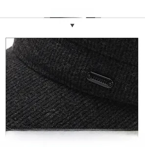 Detailansicht der schwarzen Wintermütze mit Tweed-Textur und seitlicher Zierschnalle