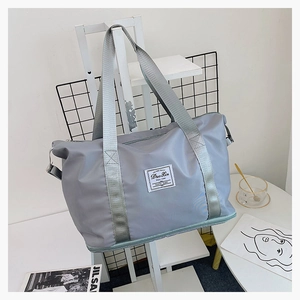 Detail of grey nylon travel bag showing waterproof fabric and bottom zipper expansion layer