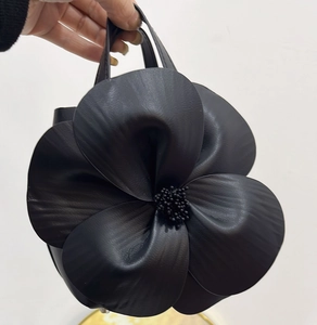 Detailed macro view of black 3D petal tote bag showing exquisite floral texture and stamen