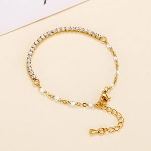 Detail of gold chain bracelet with clear rhinestones, white beads and adjustable link
