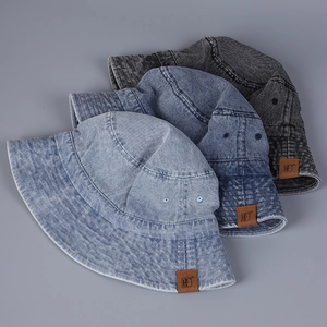Detail of washed denim bucket hats with leather HF patch and metal ventilation eyelets