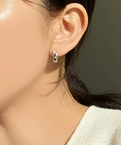 Close-up of S925 sterling silver hoop earring with irregular texture on model