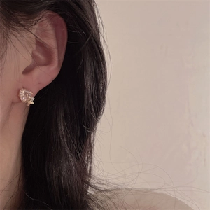 Close-up of vintage style gold-tone earrings with pink heart-shaped crystal on model