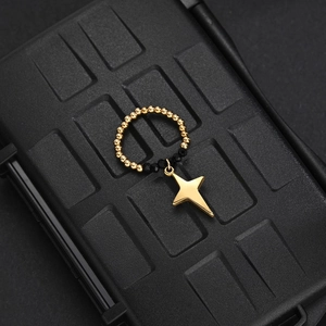 Detail of beaded ring featuring black faceted beads and a gold star-shaped charm