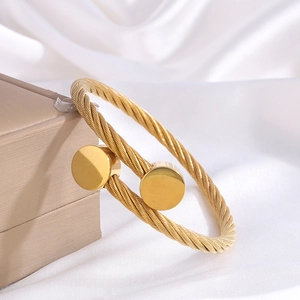 Minimalist 18k gold plated stainless steel cable cuff bracelet on white silk