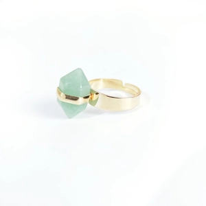 Detailed macro view of an adjustable gold ring with a green hexagonal column crystal